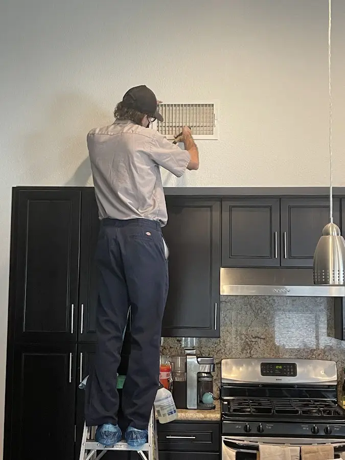 Technician inspecting an air vent during HVAC service in Port Huron